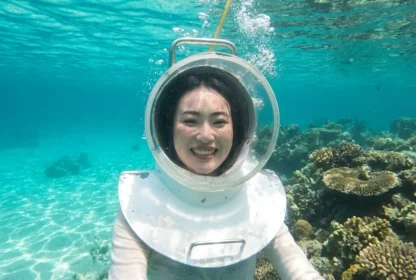 Certified instructor helping a guest with their oxygen helmet before descending for an ocean walk.